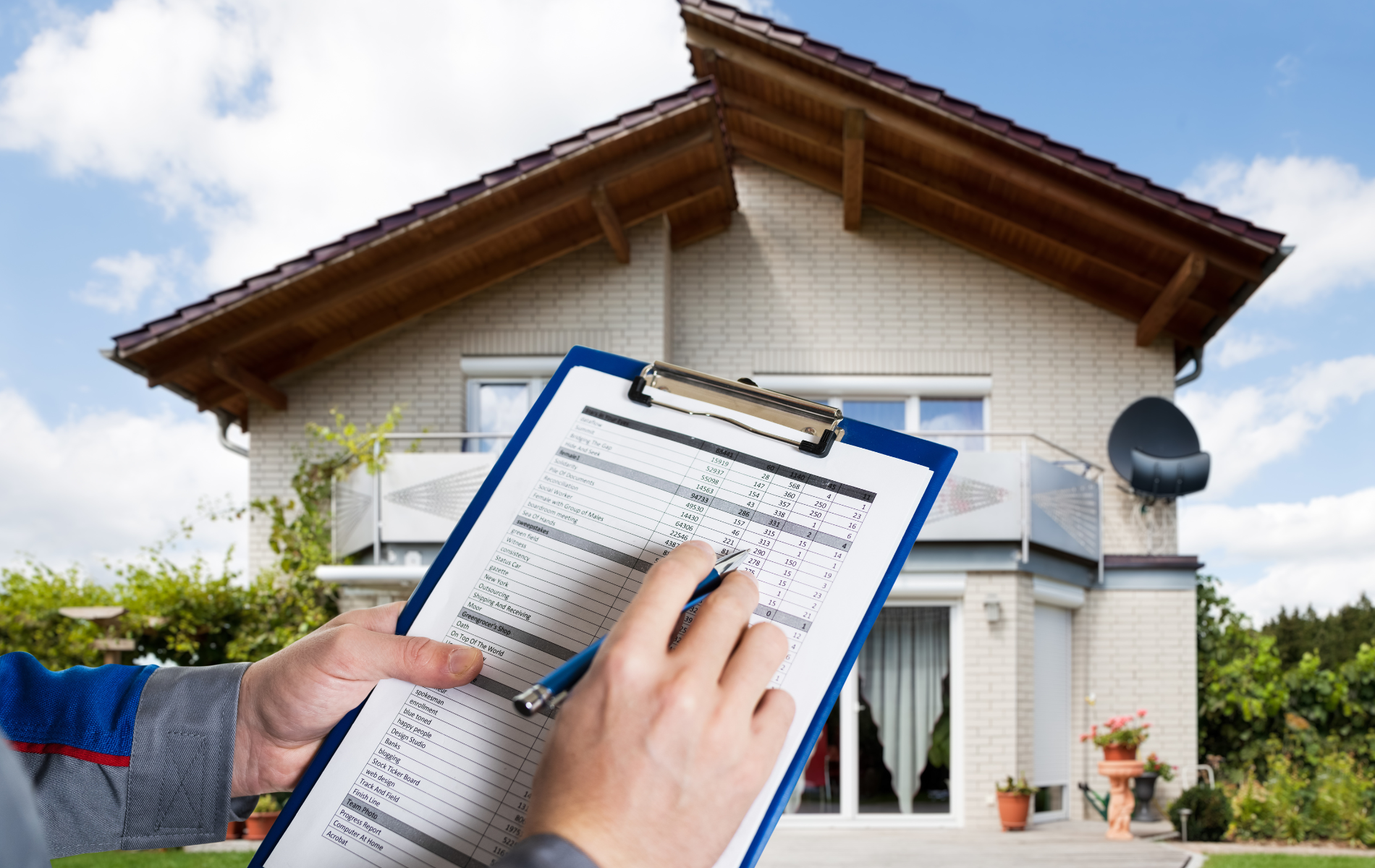 A person is holding a clipboard in front of a house