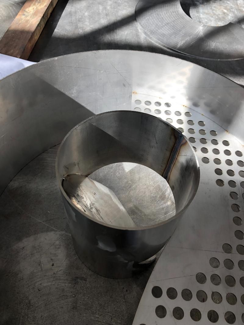 Una ciotola in acciaio inossidabile è posizionata sopra una piastra metallica.