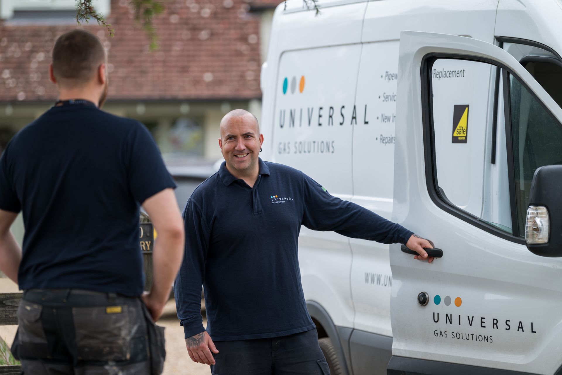 A group of five men in navy shirts posing. Indoor setting with blue wall, serious expressions.