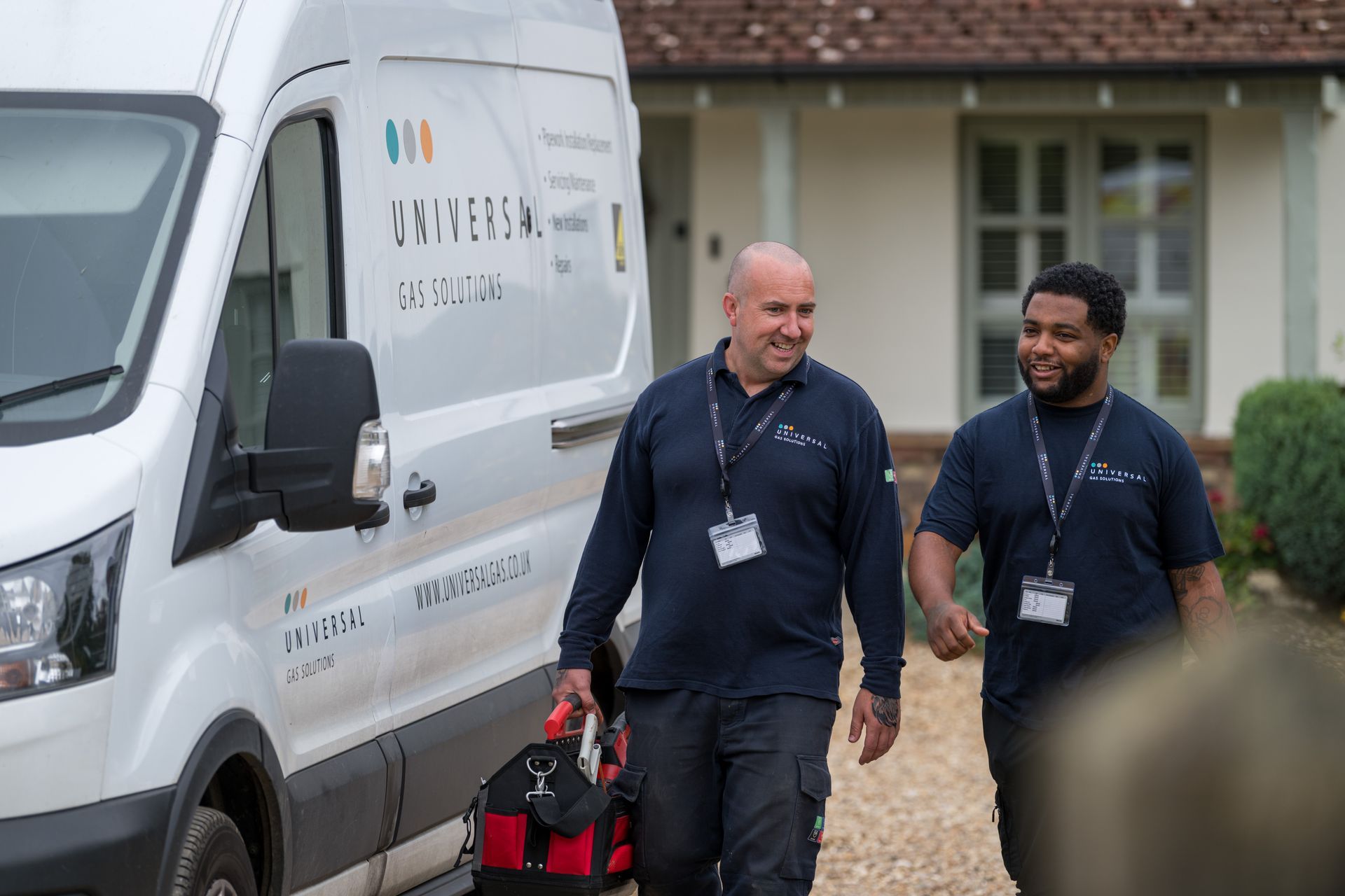 A group of five men in navy shirts posing. Indoor setting with blue wall, serious expressions.