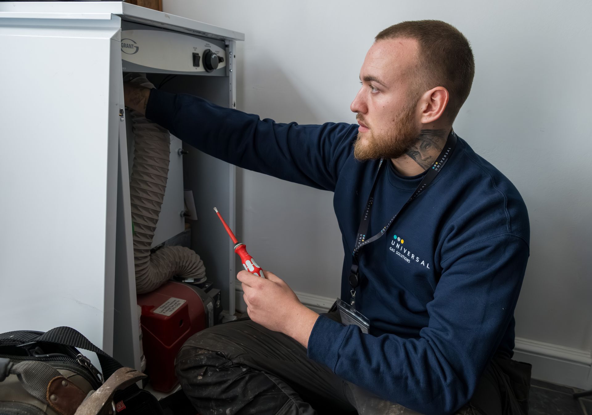 A group of five men in navy shirts posing. Indoor setting with blue wall, serious expressions.