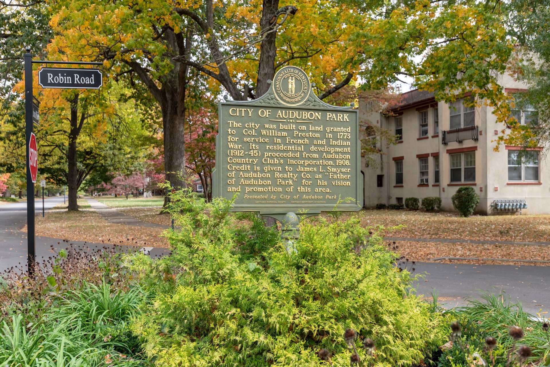 There is a historical marker in the middle of a park.
