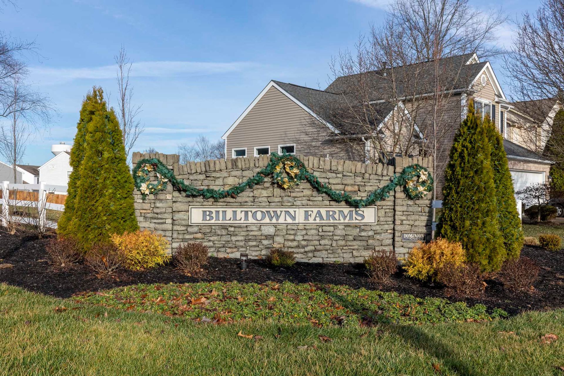 a stone sign for billtown farms is in front of a house .