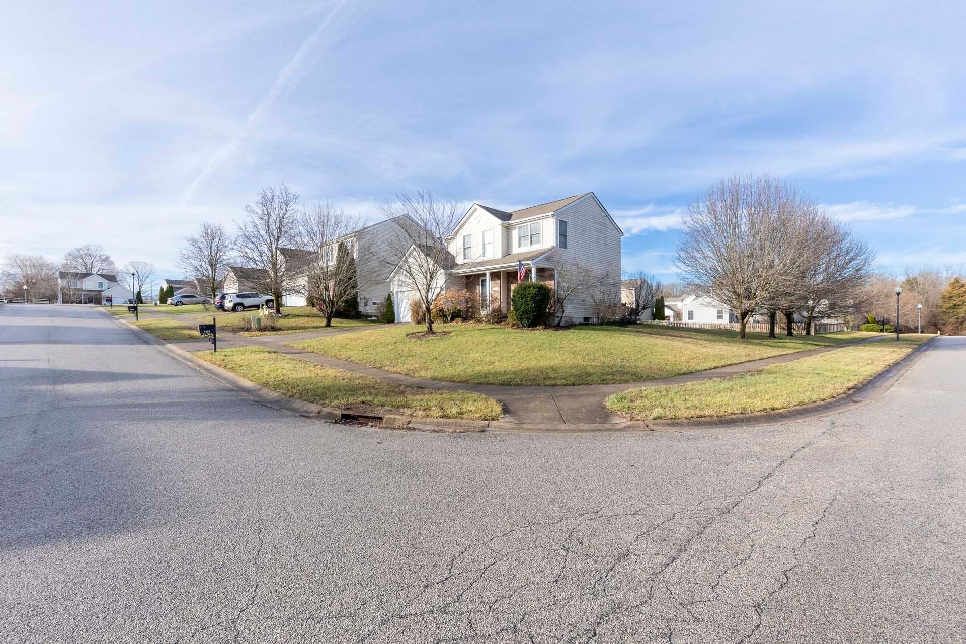 a house is sitting on the corner of a street in a residential neighborhood .