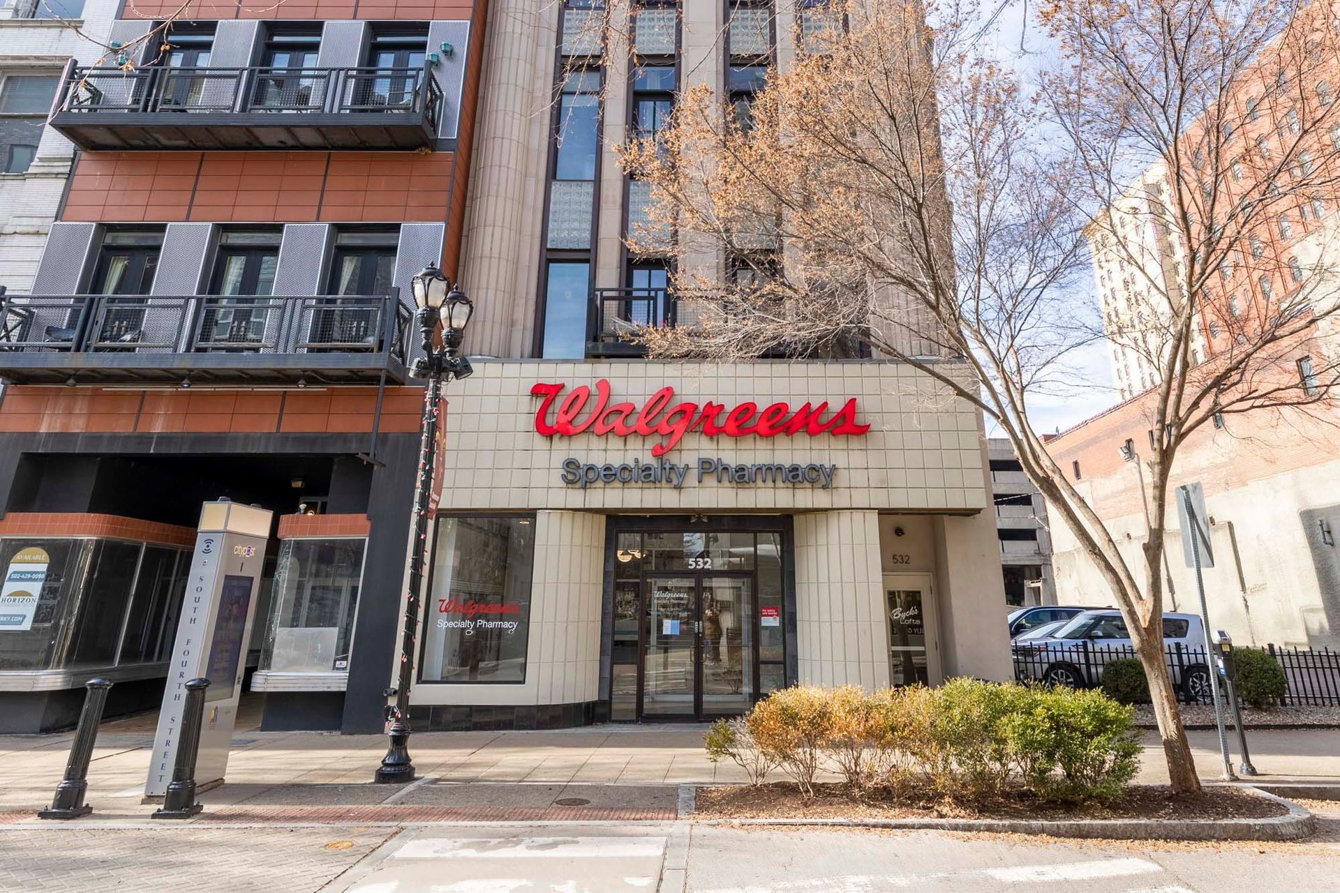 a walgreens pharmacy is located on the corner of a city street .