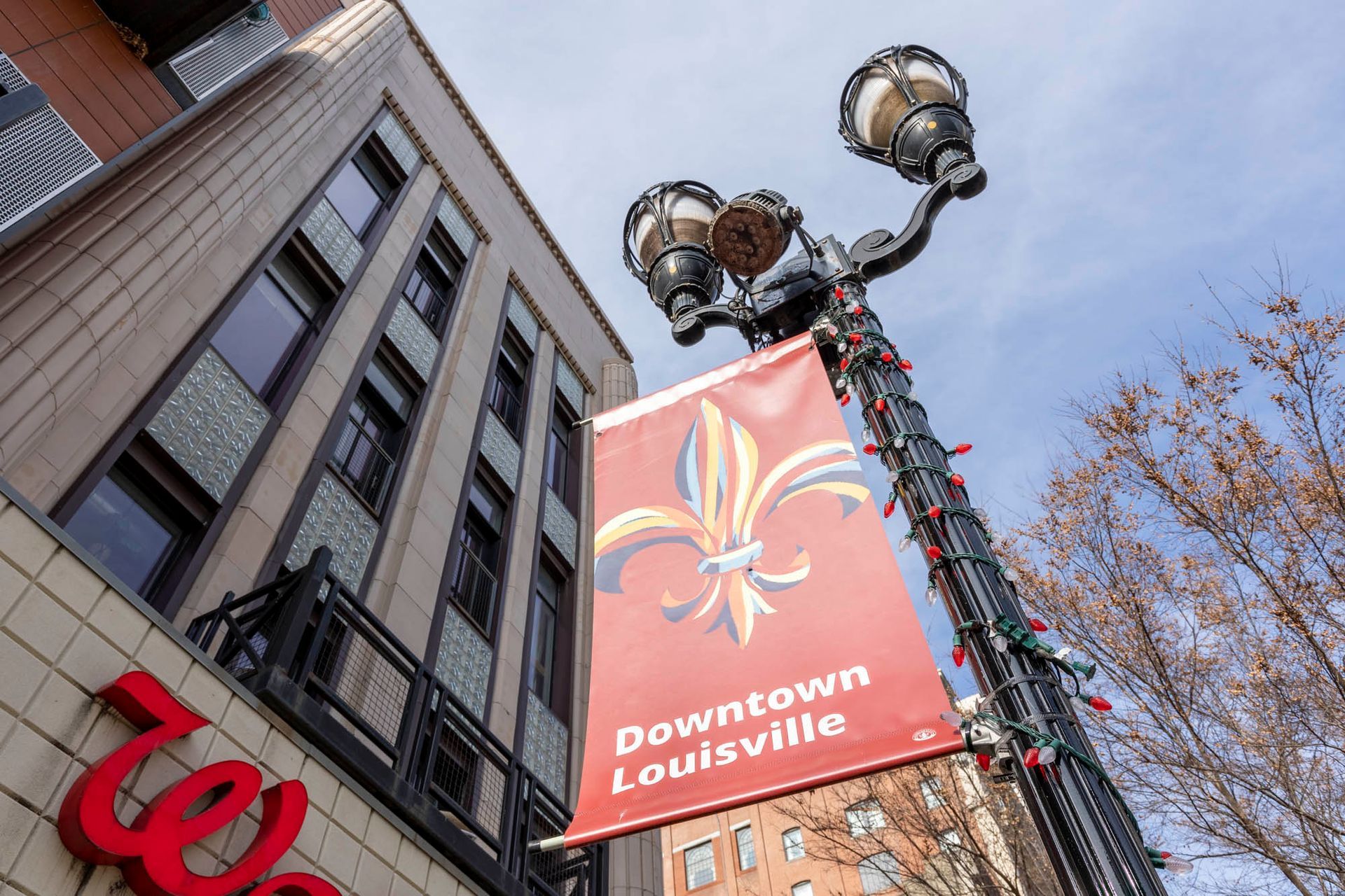 a street light with a sign that says downtown louisville on it .