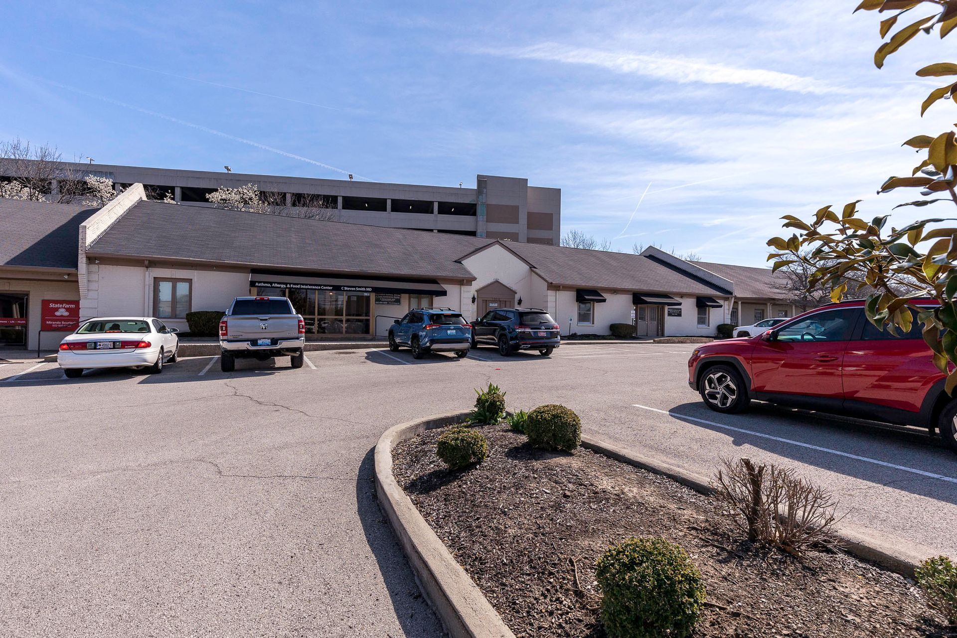 A parking lot with cars parked in front of a building.