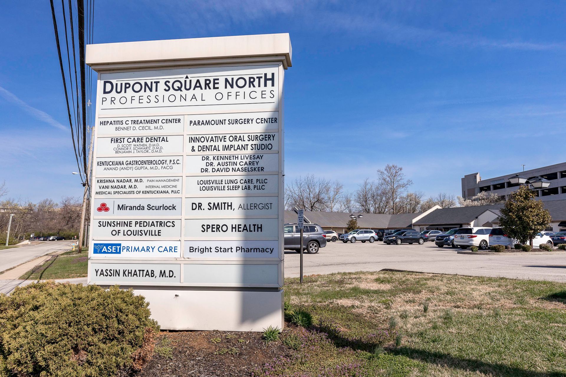 A sign for dupont square north professional offices in a parking lot