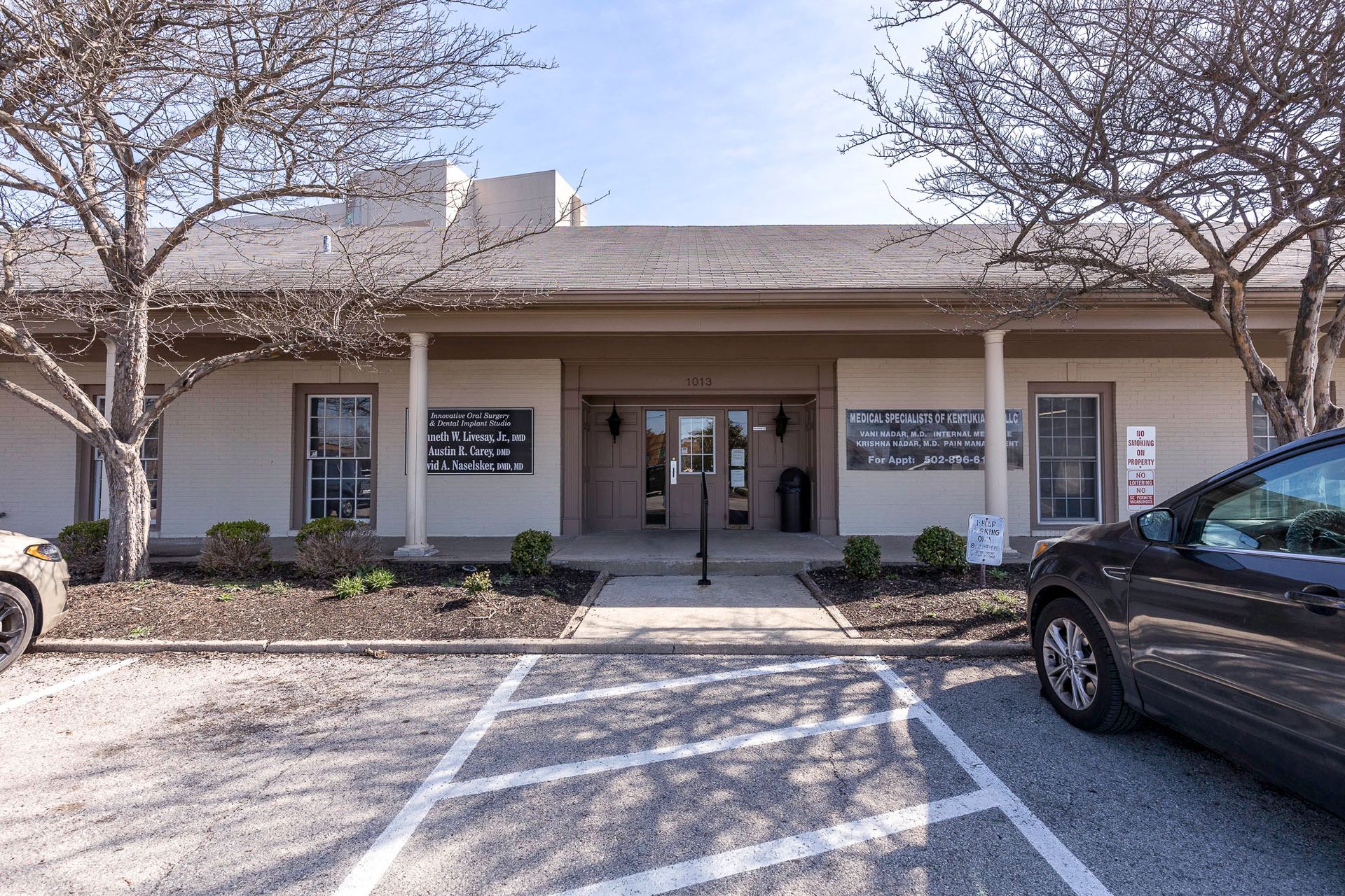 A large building with a lot of cars parked in front of it.