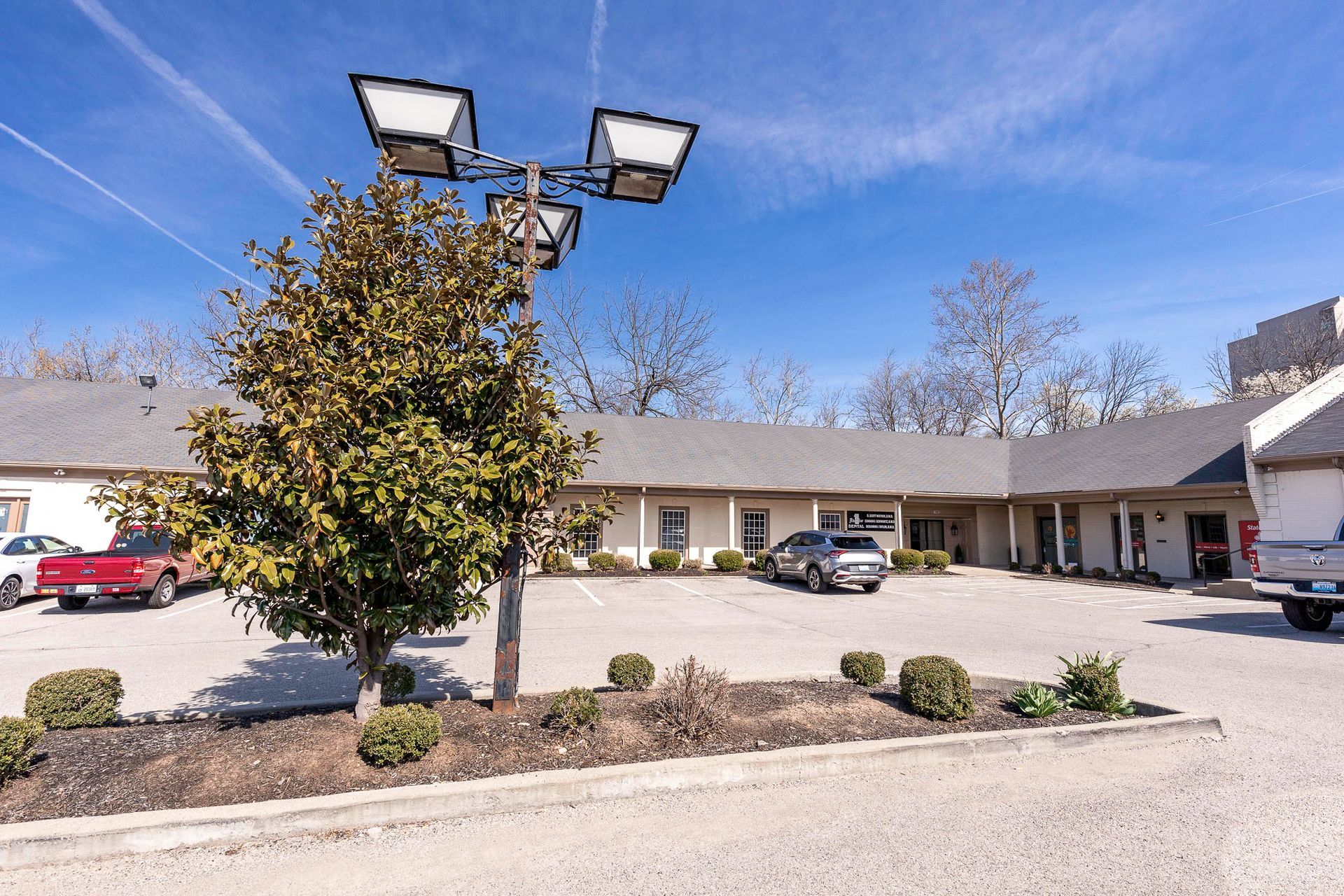 A car is parked in a handicapped parking spot in front of a building.