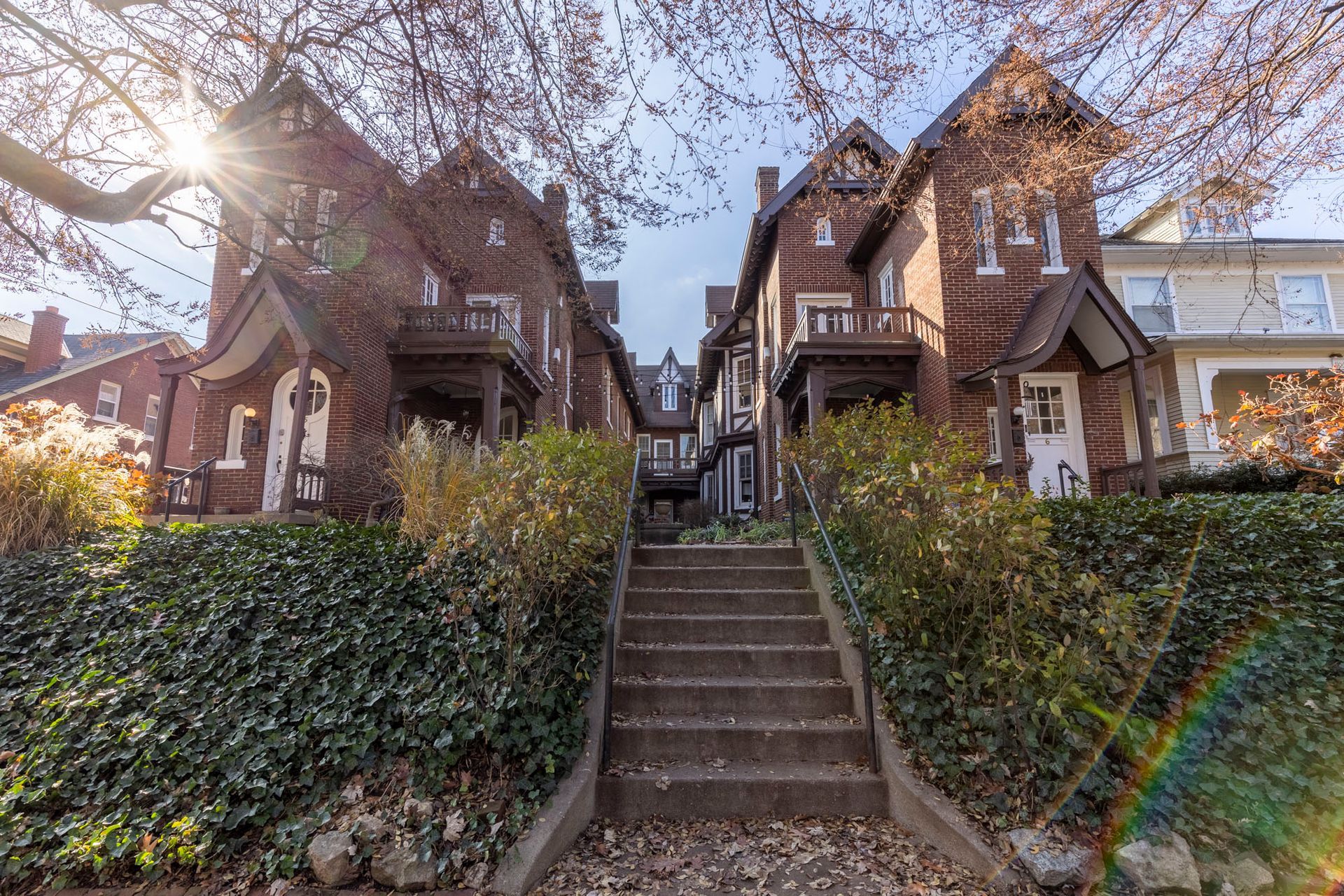 a row of brick houses with stairs leading up to them .