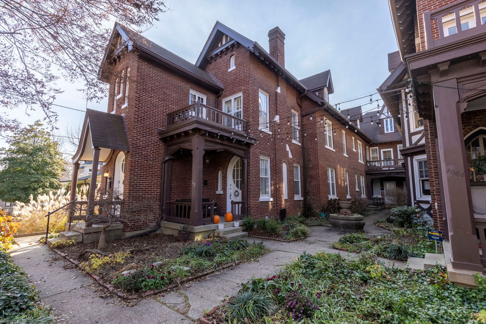 a large brick house with a porch and a garden in front of it .