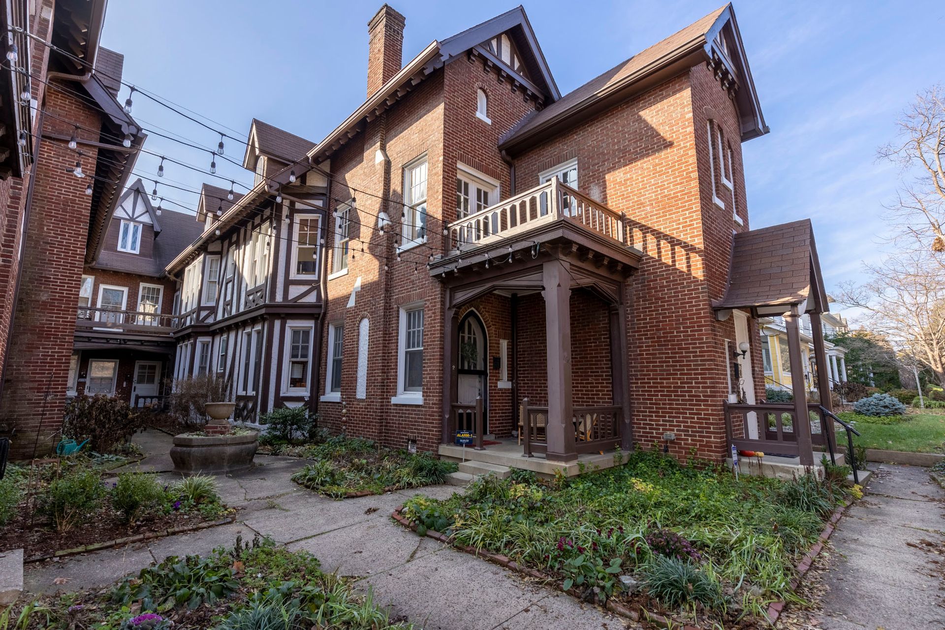 a large brick house with a porch and a lawn in front of it .