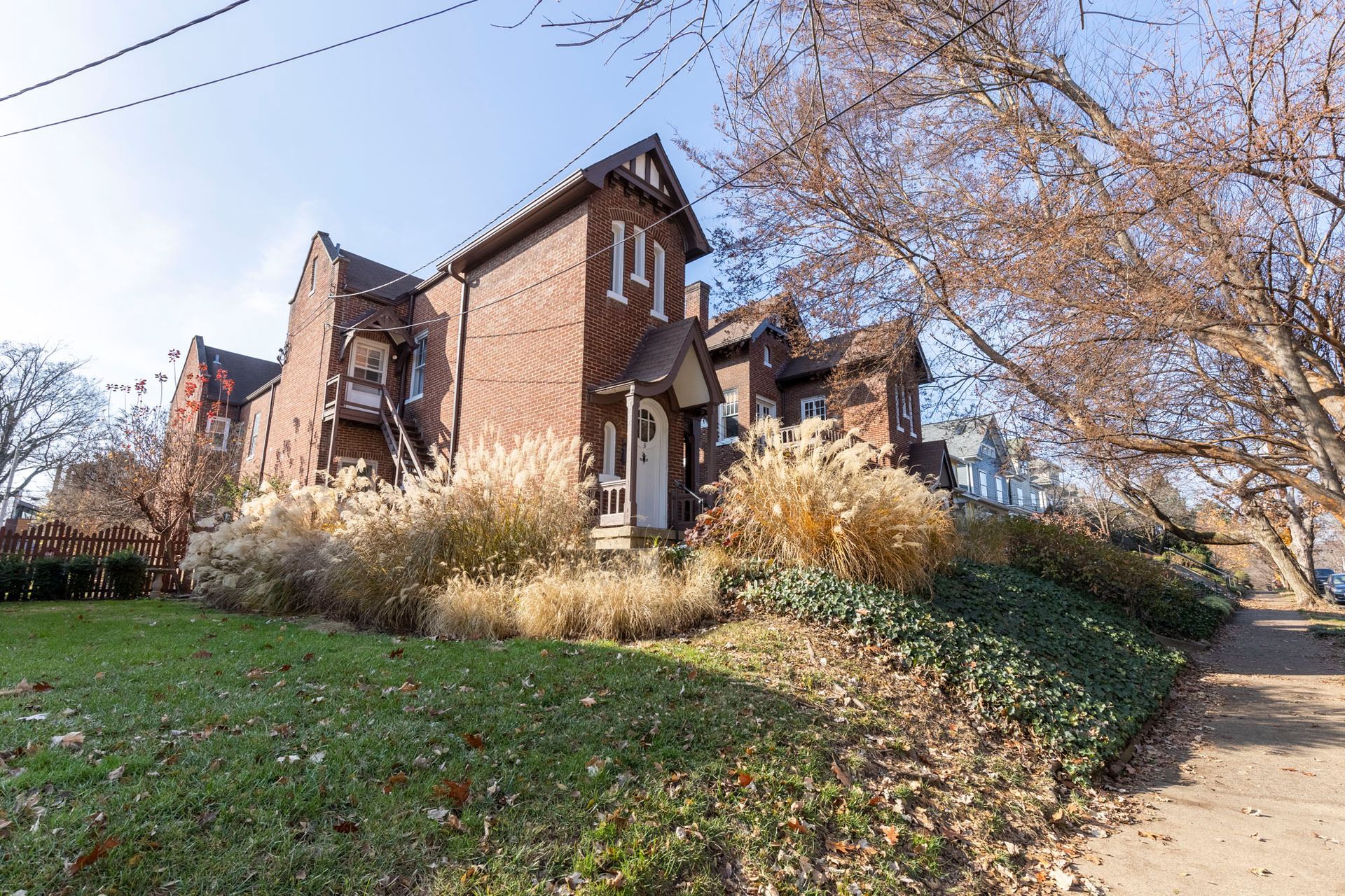 a large brick house with a lot of plants in front of it .