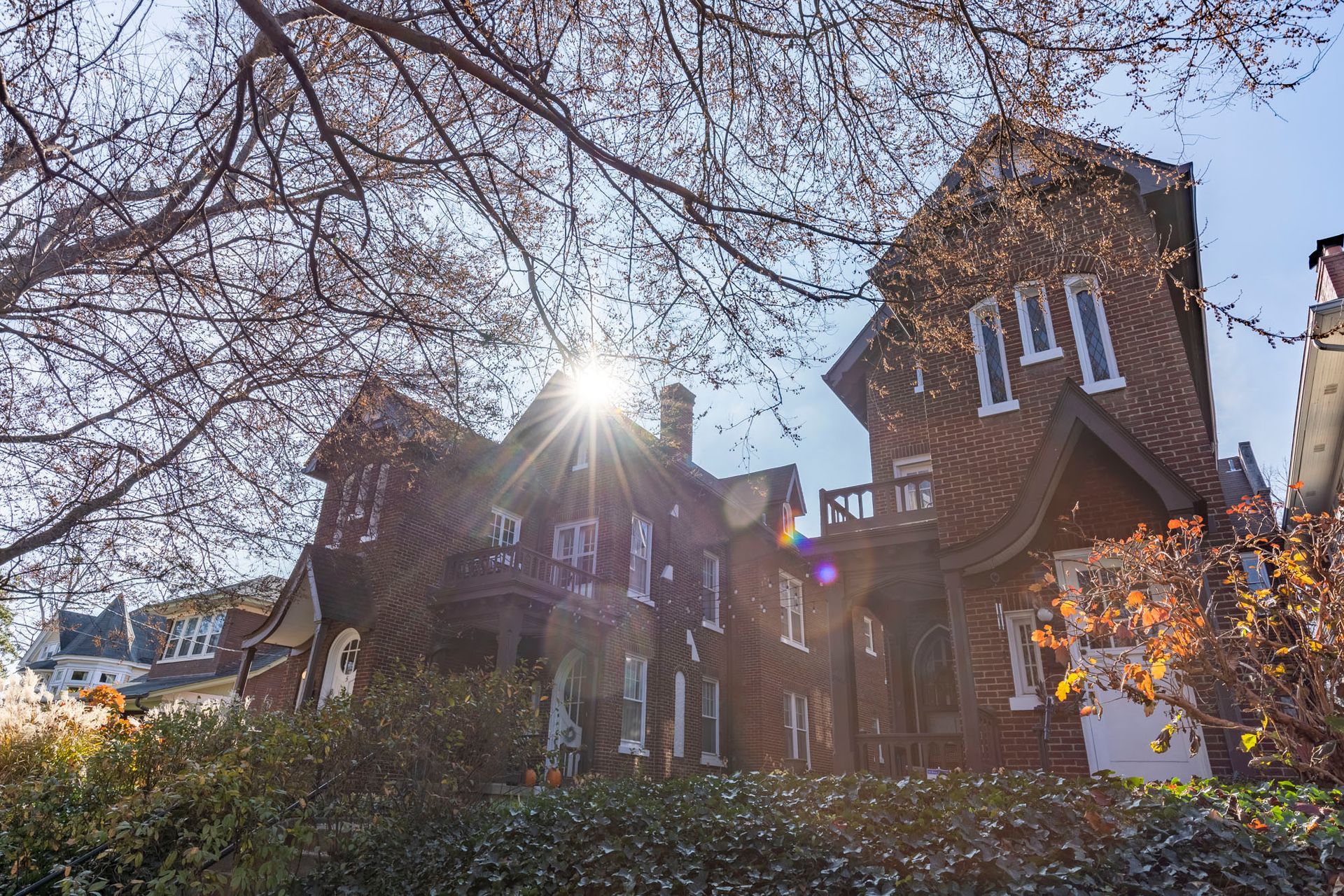 the sun is shining through the trees in front of a large building