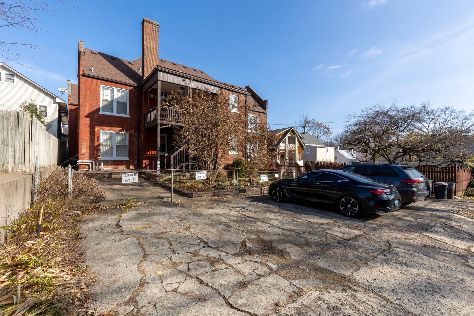 a row of cars are parked in front of a large brick building .