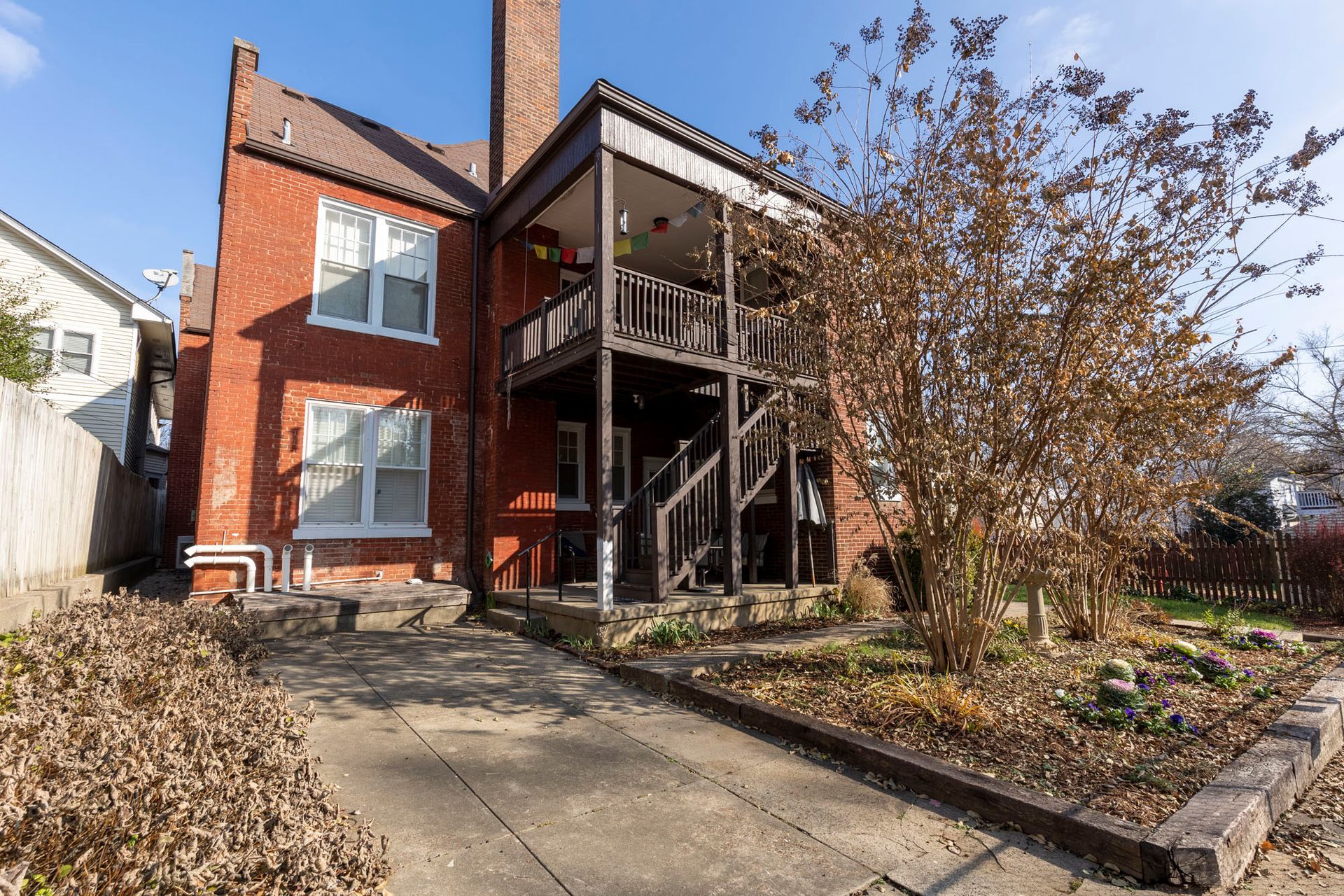 a large brick house with a balcony and stairs in the backyard .