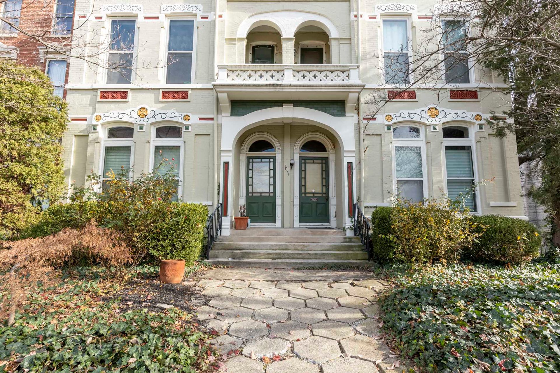 The front of a large house with a stone walkway leading to it.