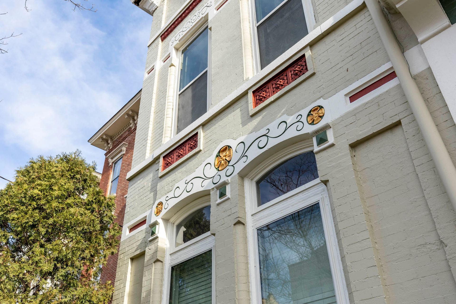 A large brick building with a lot of windows and a stained glass window.