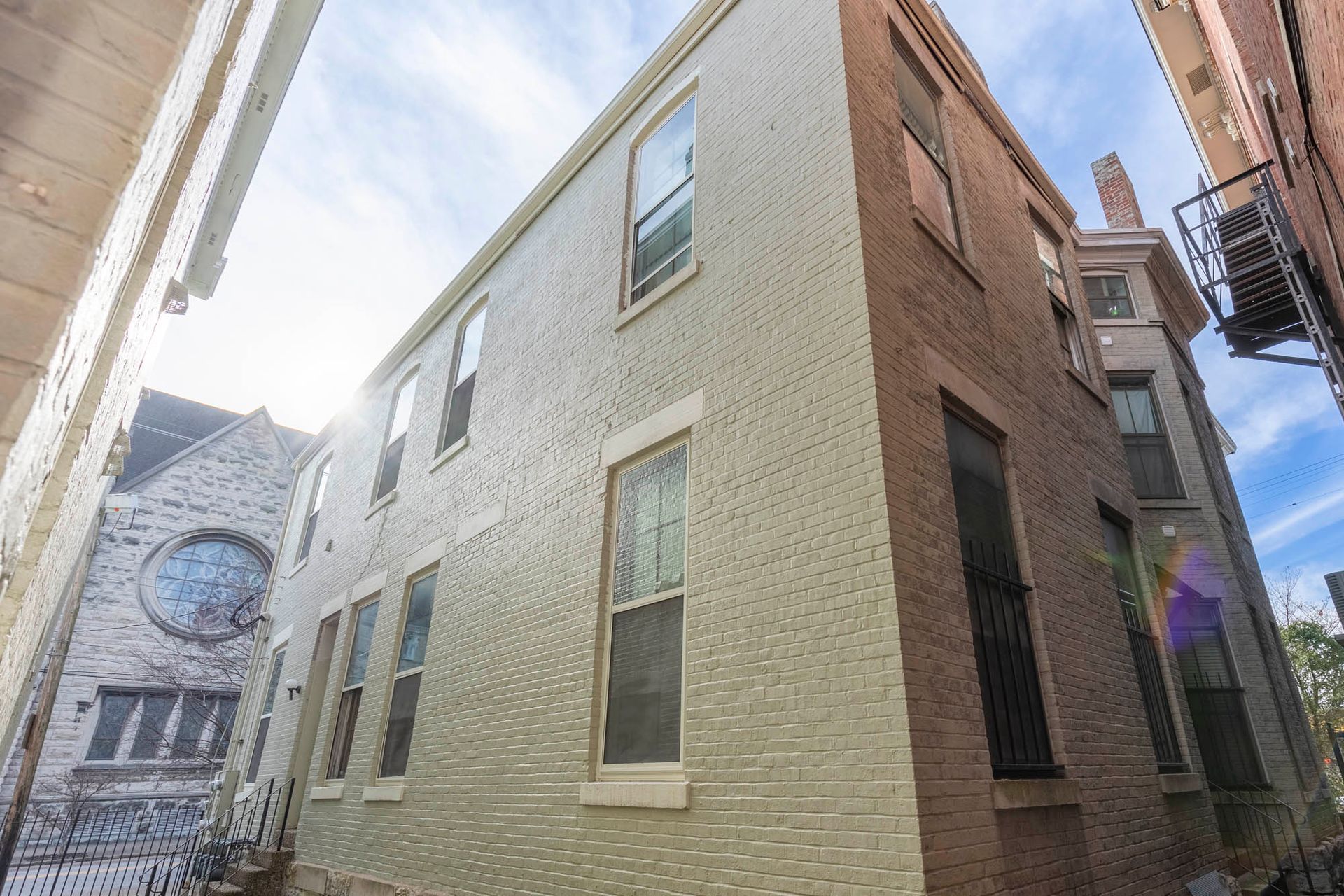 A white brick building with a clock on the side of it