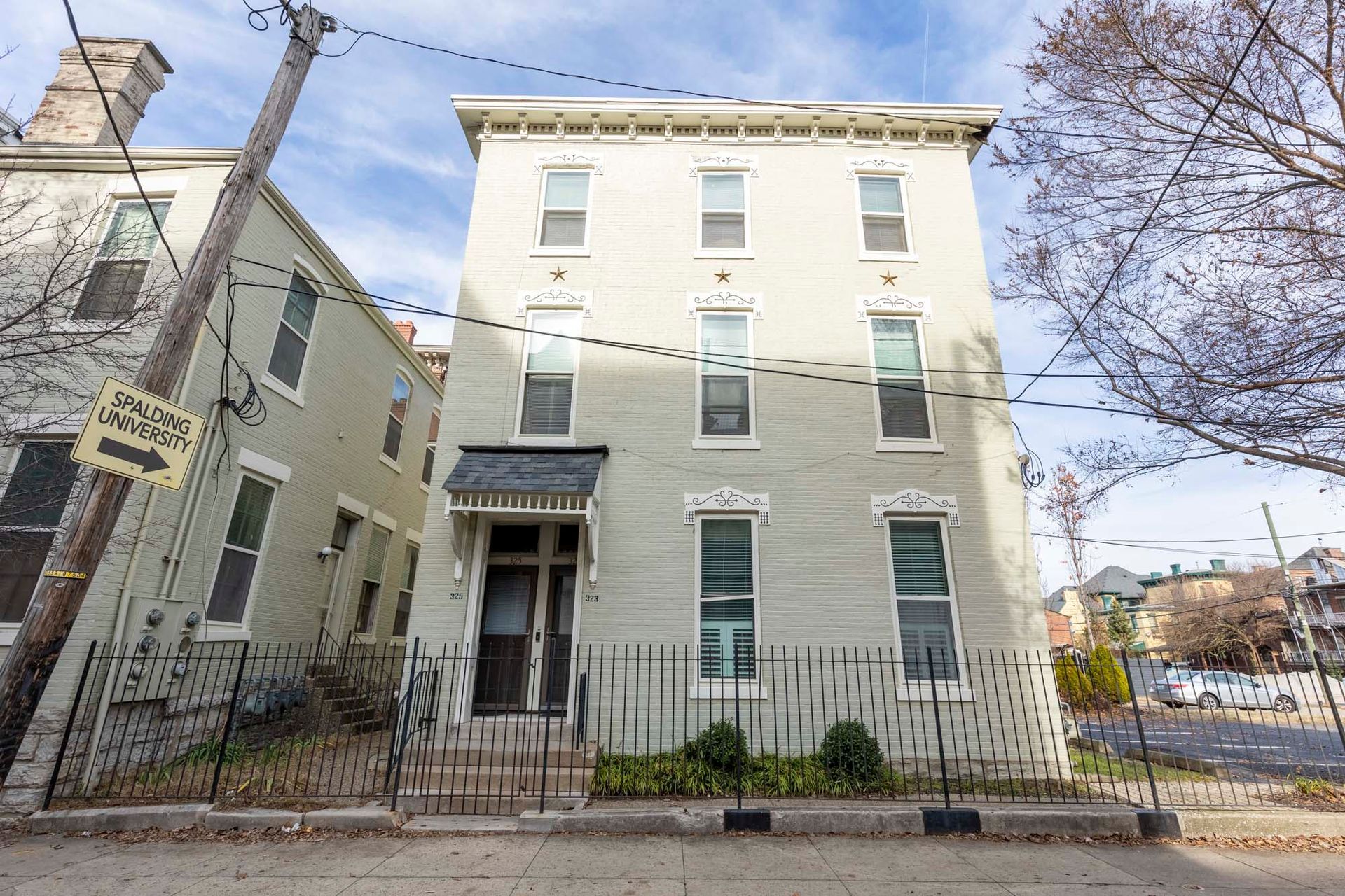 A large white building with stairs leading up to the front door.