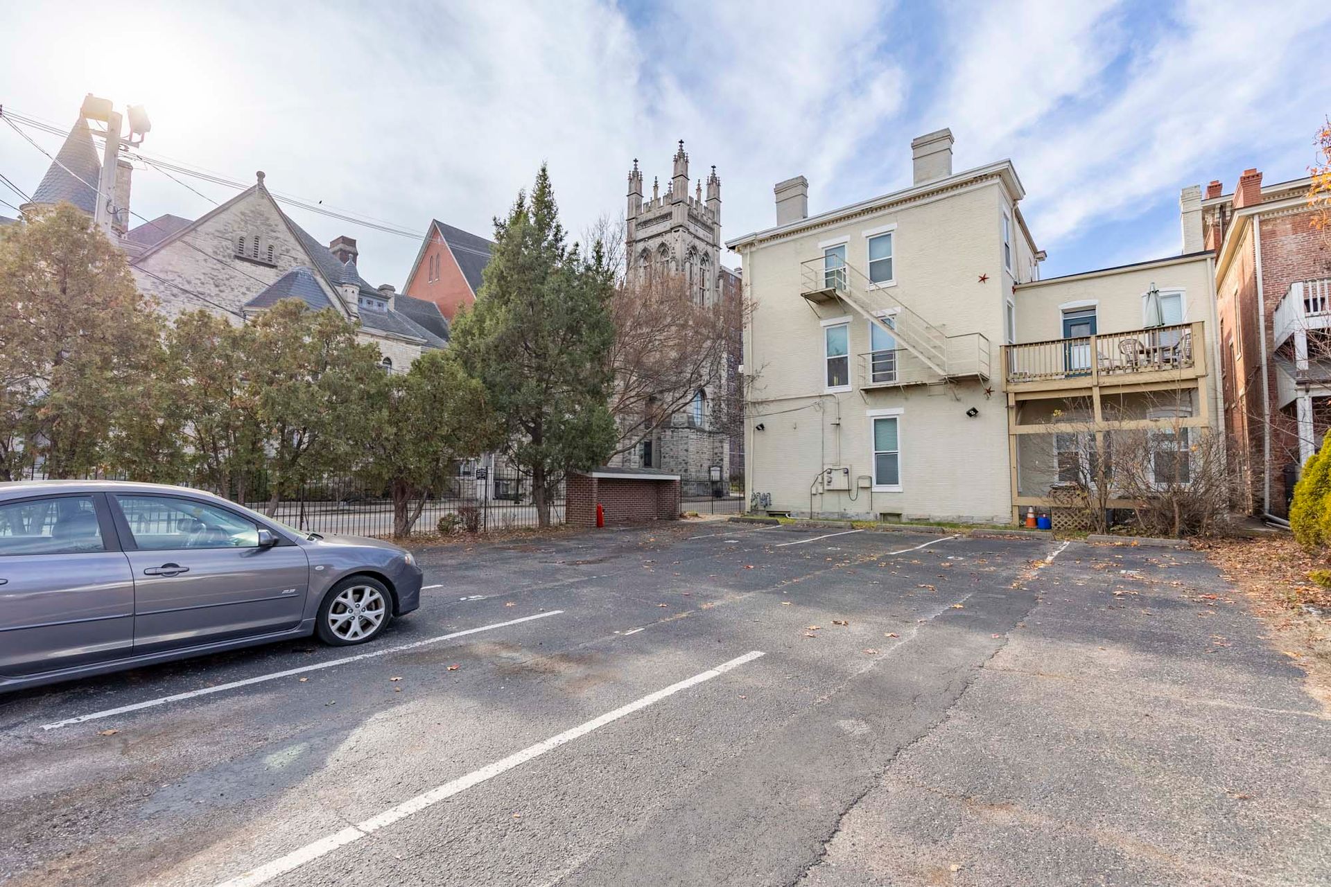 A car is parked in a parking lot in front of a building.