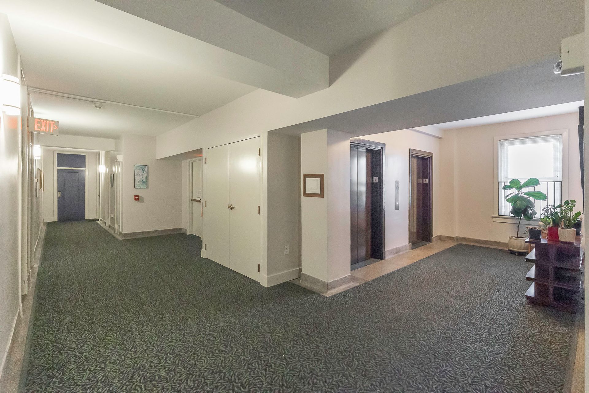 A long hallway with two elevators in a building