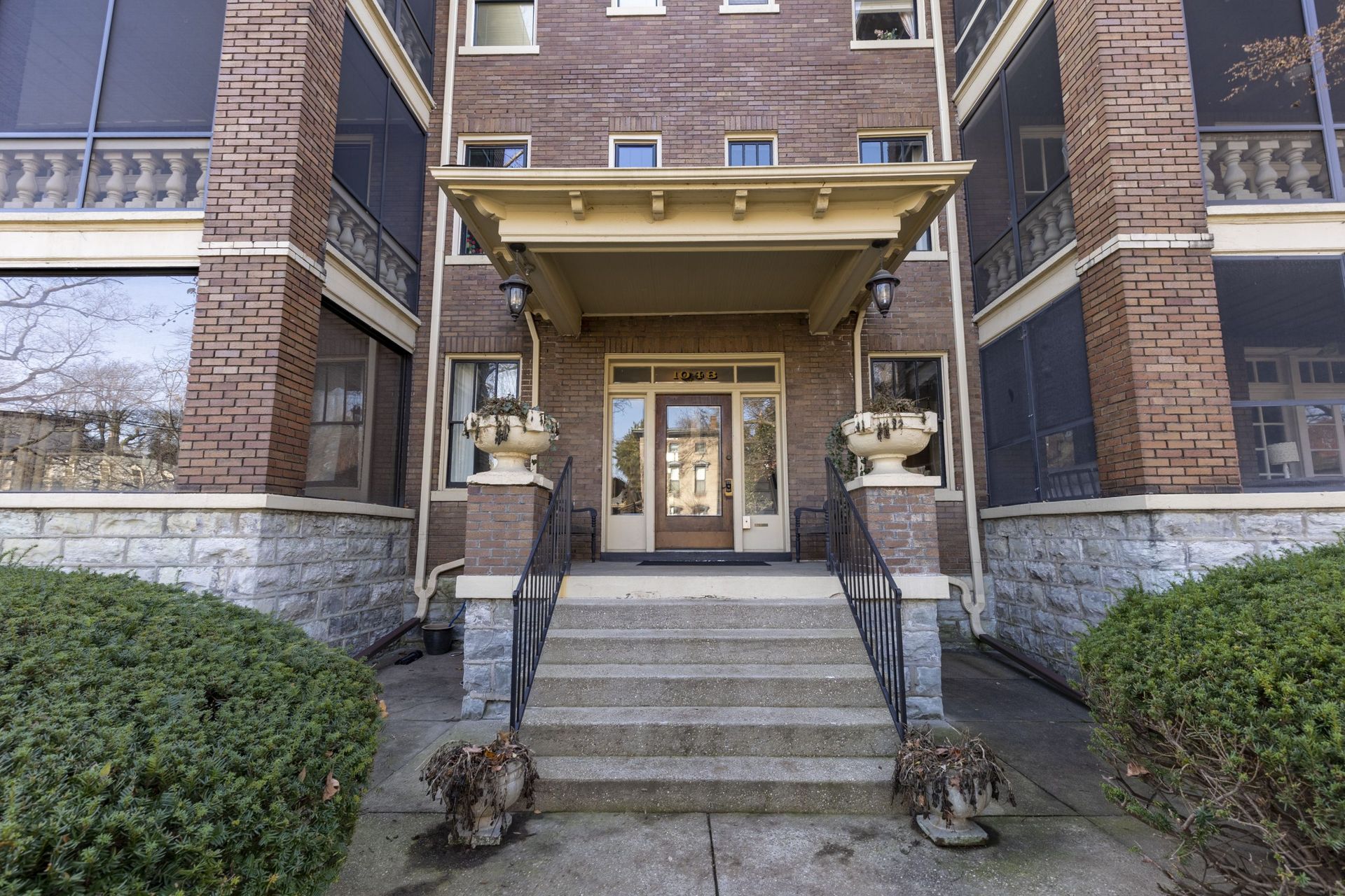 a brick building with a screened in porch and stairs