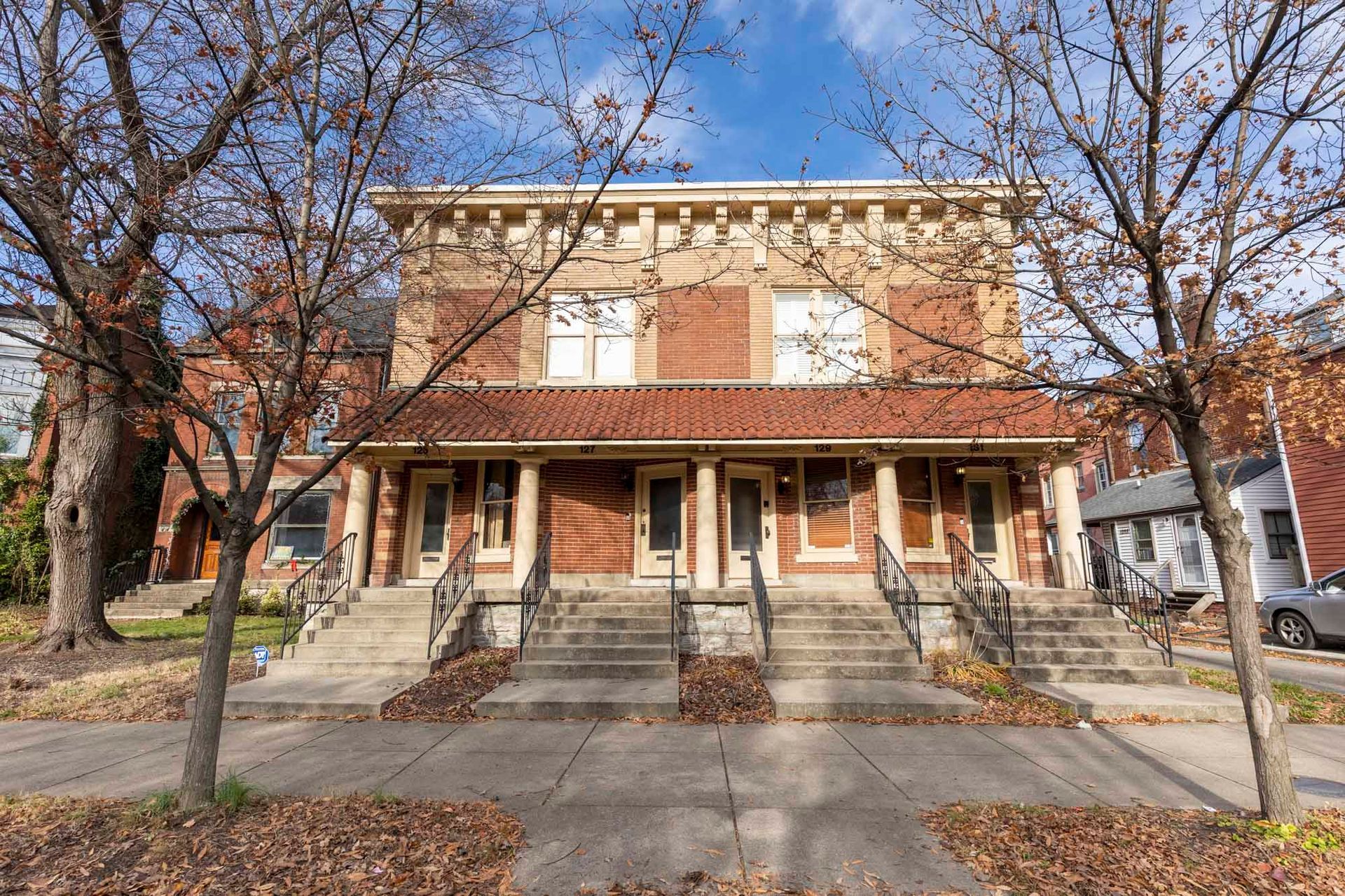 a large brick building with stairs and a car parked in front of it .