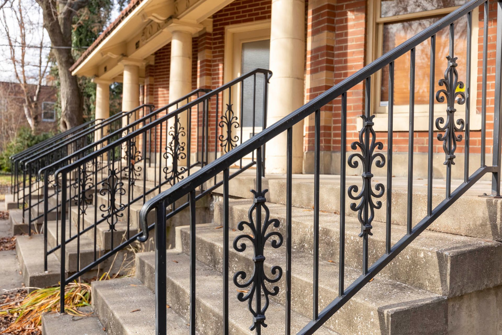 a wrought iron railing on the stairs of a brick building .
