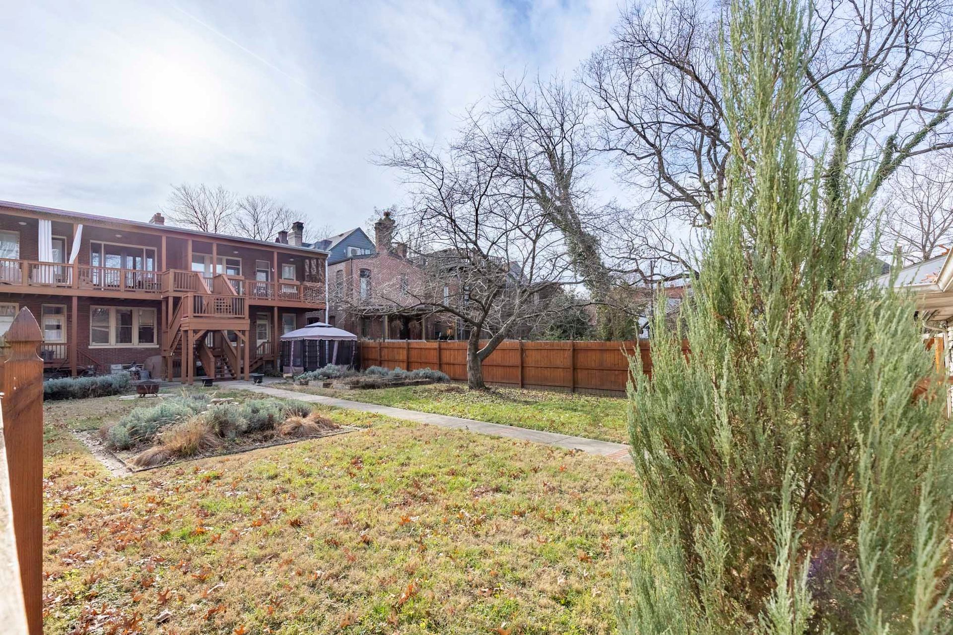 a large backyard with a fence and a house in the background .