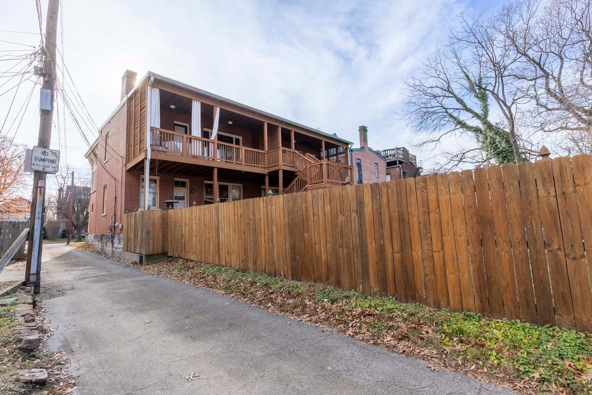 a wooden fence surrounds a brick building next to a road .