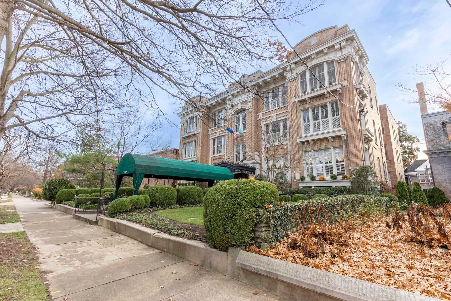 a large brick building with a green awning on the side of it .