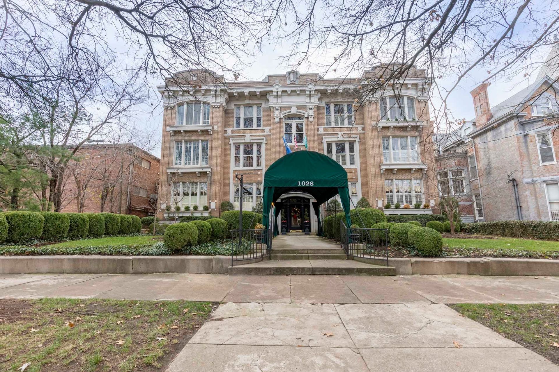 a large brick building with a green awning over the entrance .