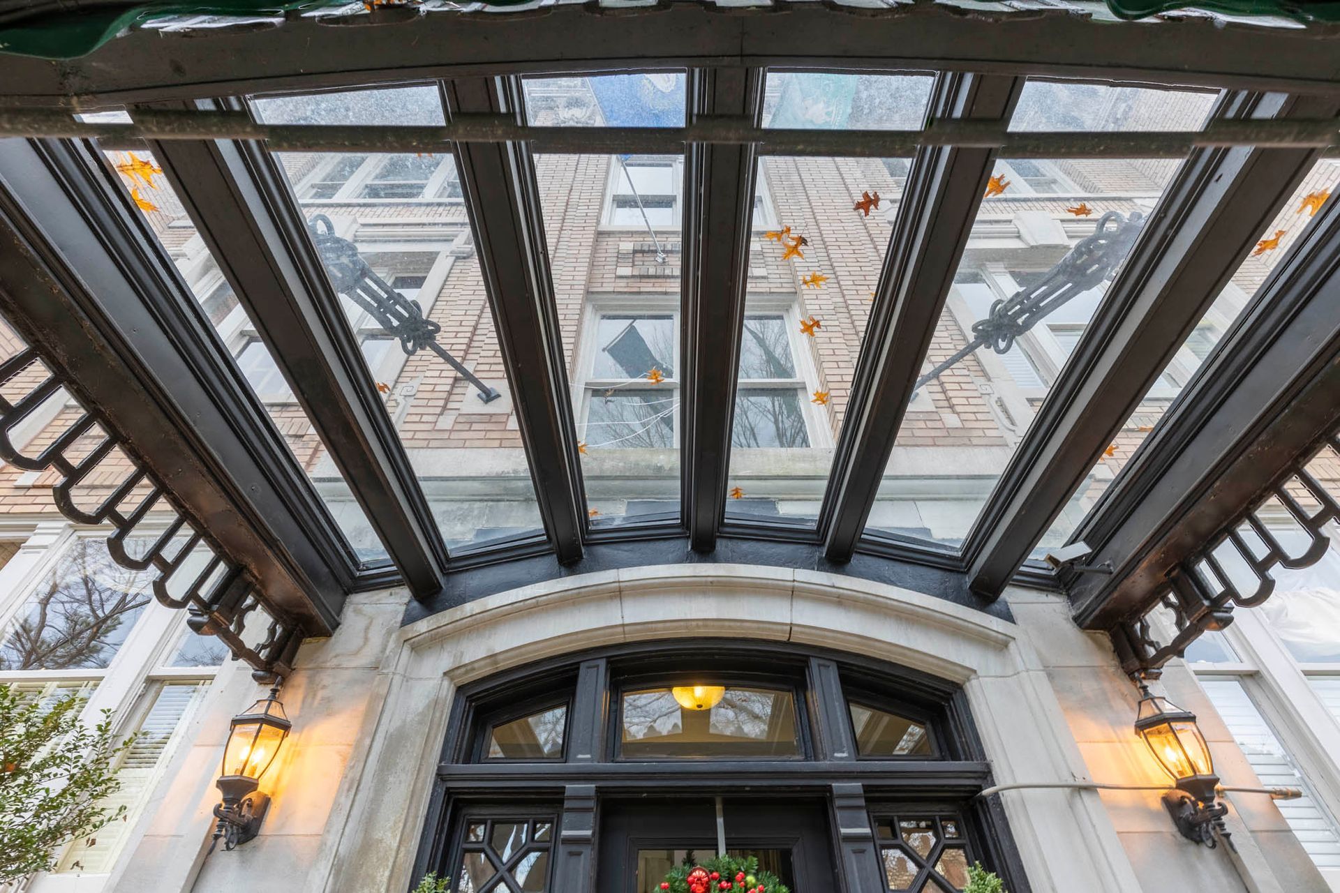 the front door of a building with a glass canopy over it .