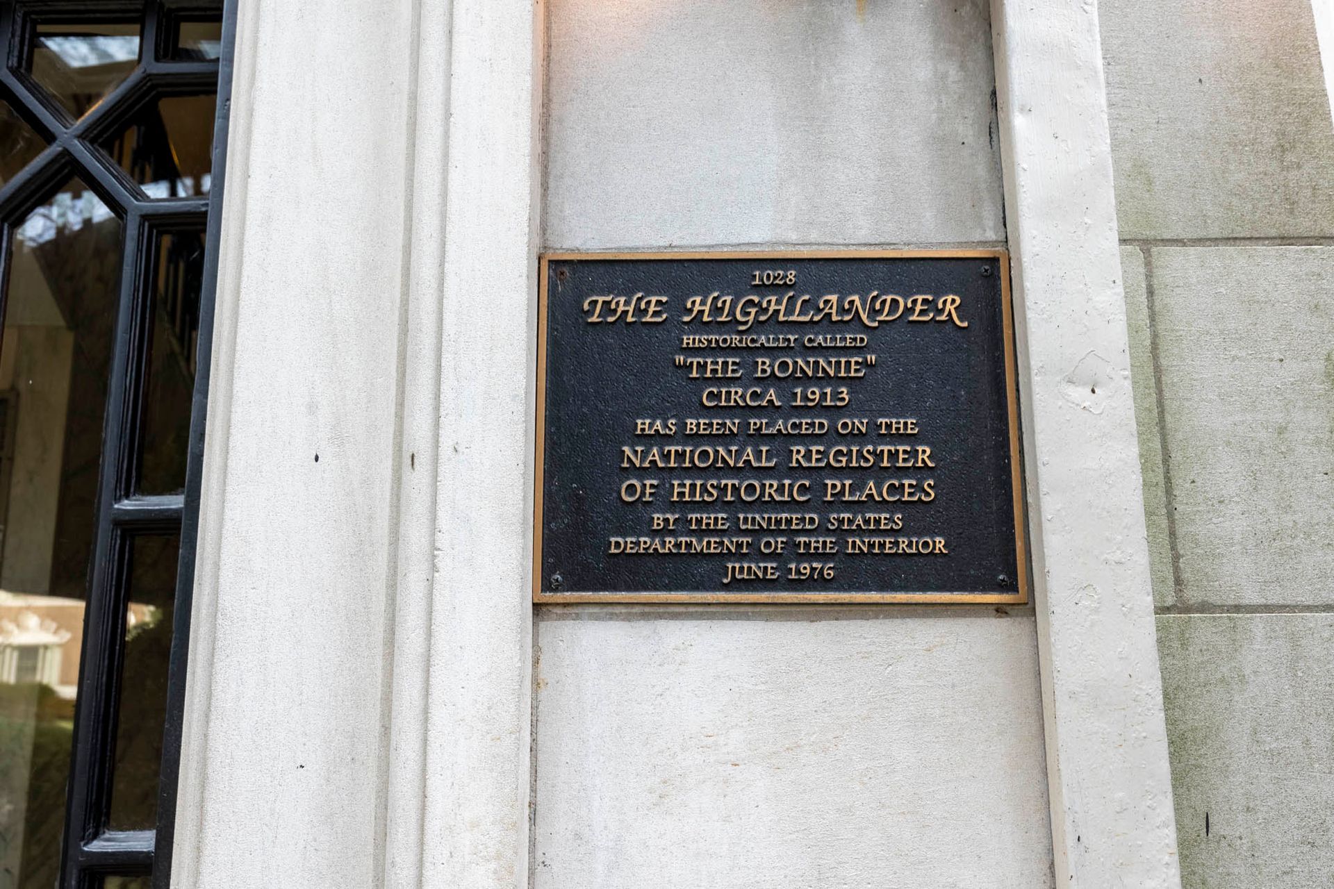 a plaque on the side of a building that says the highlander