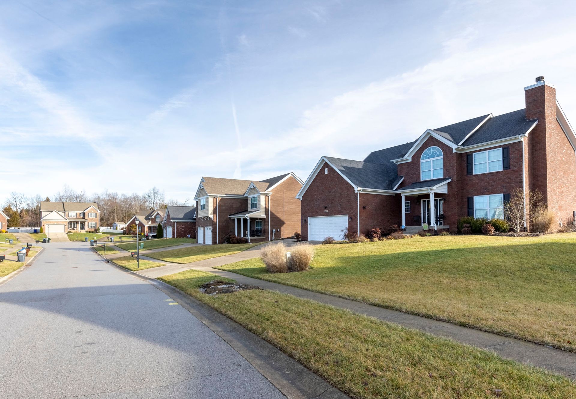 a row of houses in a residential neighborhood on a sunny day .