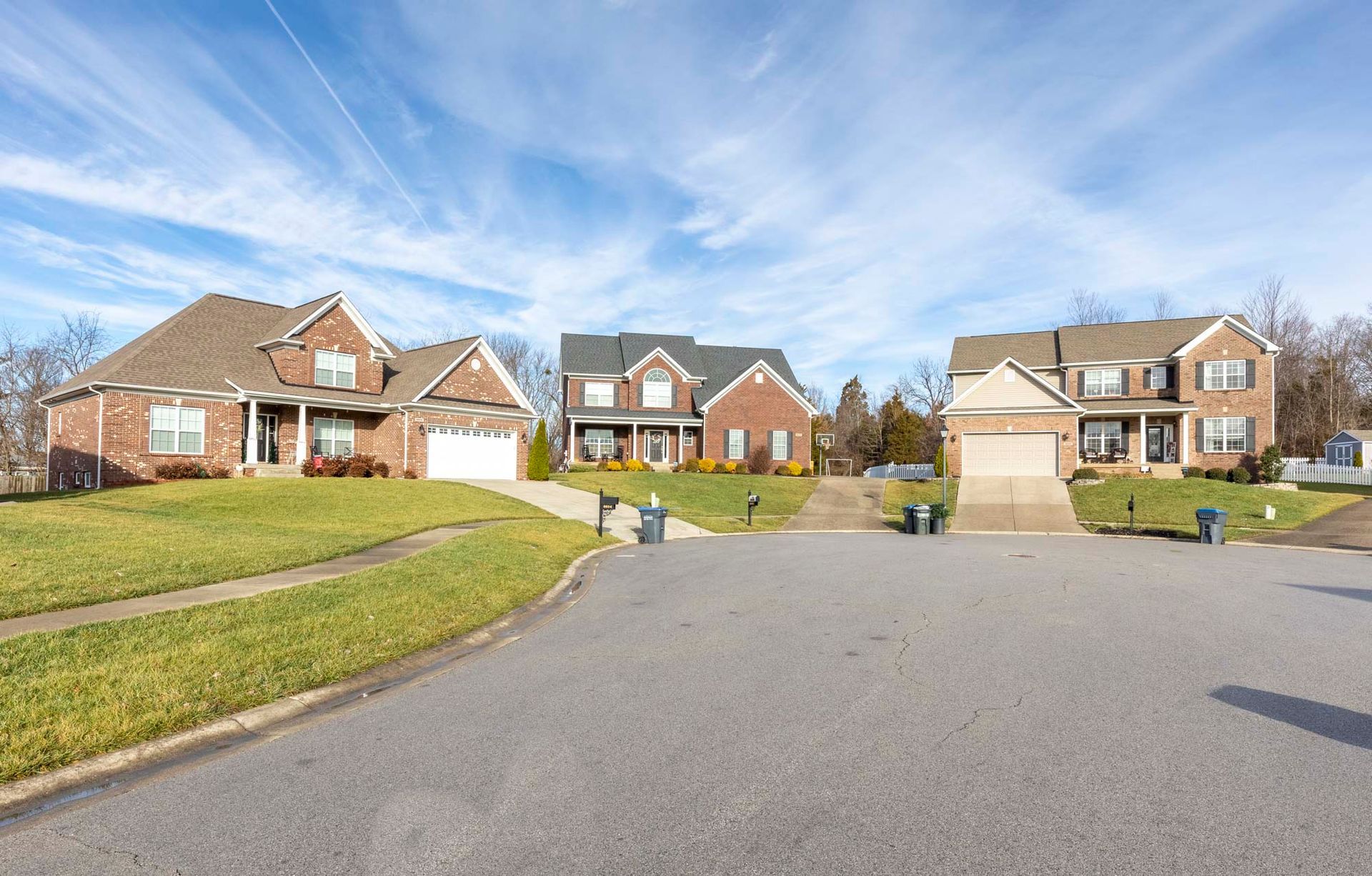 a row of houses on a sunny day in a residential neighborhood .