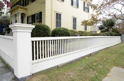 White Fencing around a yellow house Holbrook MA Mutual Fence Co Llc
