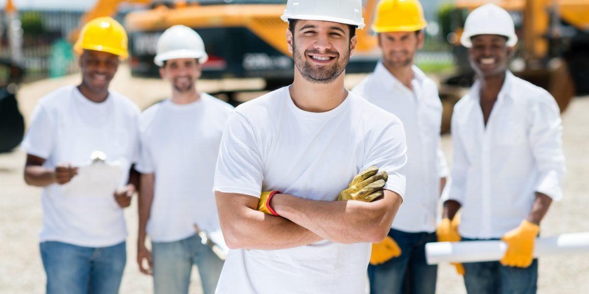A group of construction workers are standing next to each other on a construction site.