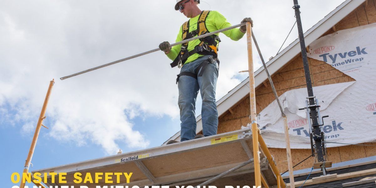 A man is standing on a scaffolding on top of a building.