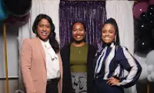 Three women are posing for a picture in a photo booth.
