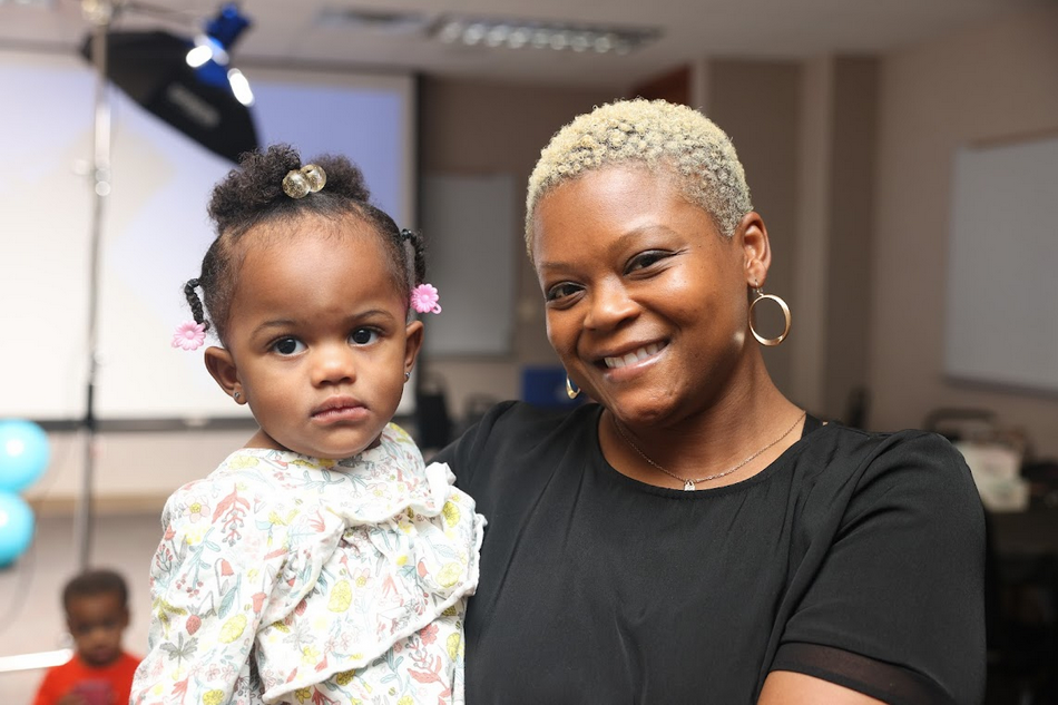 A woman is holding a little girl in her arms.