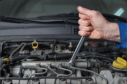 Hand of auto mechanic with a wrench