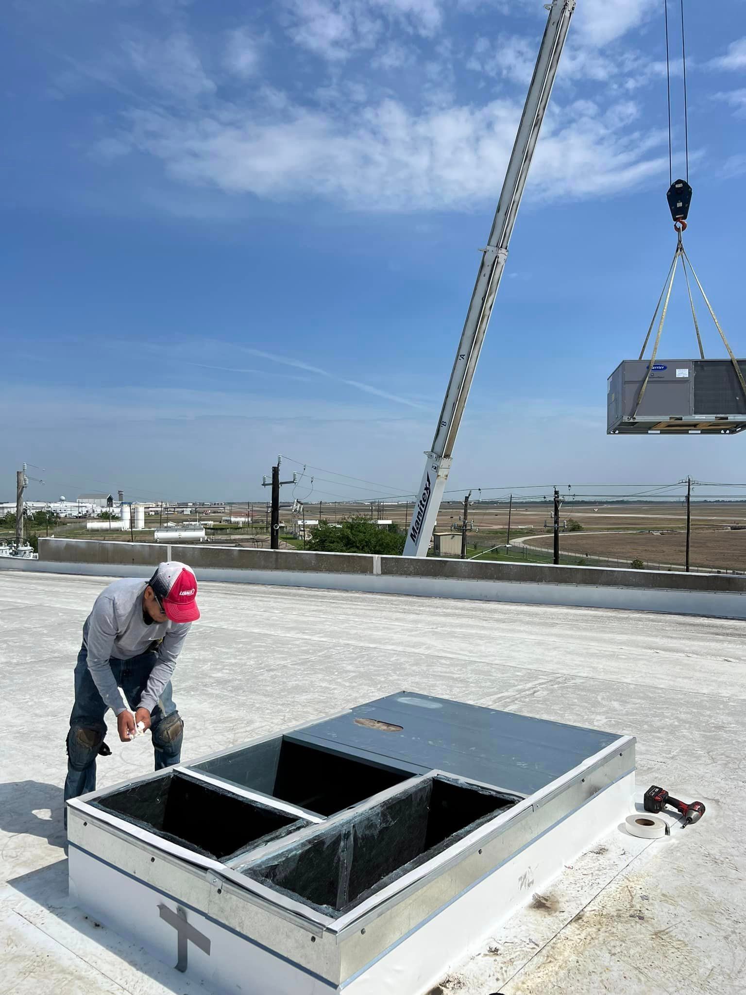 A man is working on a roof with a crane.