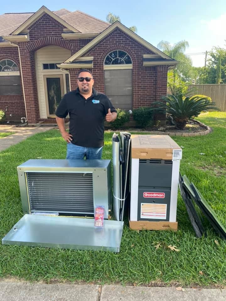 A man is standing in front of a brick house with a heater and air conditioner.