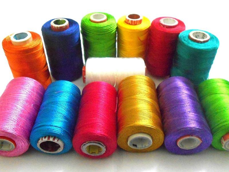 A bunch of colorful spools of thread on a table