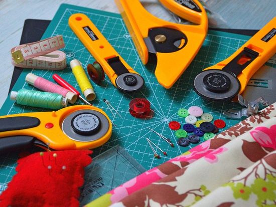 A cutting mat with sewing tools and buttons on it