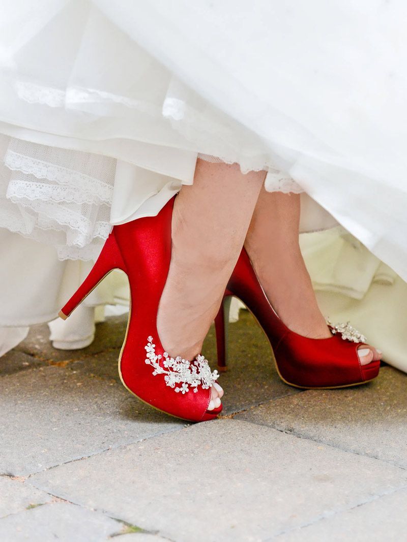 A woman wearing a white dress and red high heels