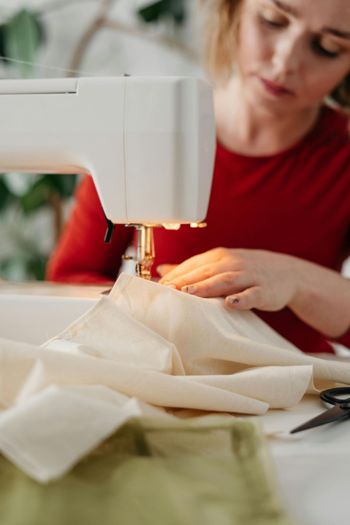 A woman is using a sewing machine to sew a piece of fabric.